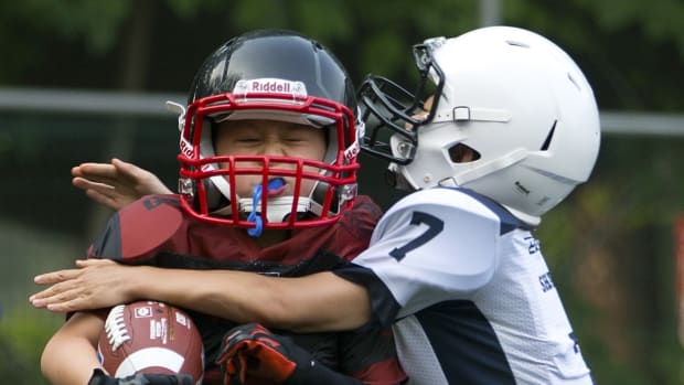 In this Sunday, July 5, 2015 photo, Ma Shichi, 9, of the Vipers, left, is tackled by Liu Jiayou, 9, of the Sharks, right, during their American football game in Beijing. Chinas capital might seem like an unlikely place to find American football, but interest among Chinese youth is growing. (AP Photo/Mark Schiefelbein)