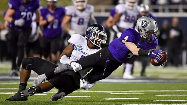 St. Thomas wide receiver Jack Gilliland (4) is tackled after his reception by Mount Union defensive back Tre Jones during the first half of the the NCAA Division III football championship game in Salem, Va., Friday, Dec. 18, 2015. (AP Photo/Michael Shroyer)