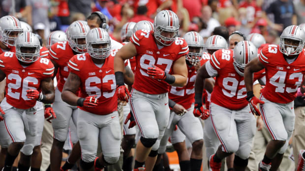 Ohio State players run onto the field at the end of a timeout in the first half of an NCAA college football game against Navy in Baltimore, Saturday, Aug. 30, 2014. (AP Photo/Patrick Semansky)