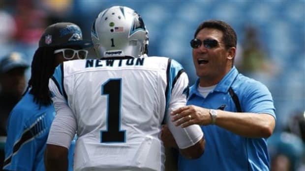 Carolina Panthers head coach Ron Rivera talks with  Cam Newton (1) before an NFL football game between the Carolina Panthers and the Jacksonville Jaguars in Charlotte, N.C., Sunday, Sept. 25, 2011. (AP Photo/Nell Redmond)
