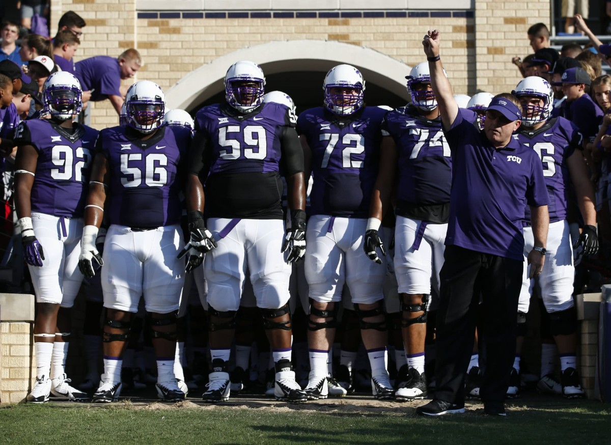 TCU head coach Gary Patterson salutes the crowd as he prepares to lead his team onto the field against Samford before an NCAA college football game in Fort Worth, Texas, Saturday, Aug. 30, 2014. (AP Photo/Jim Cowsert)