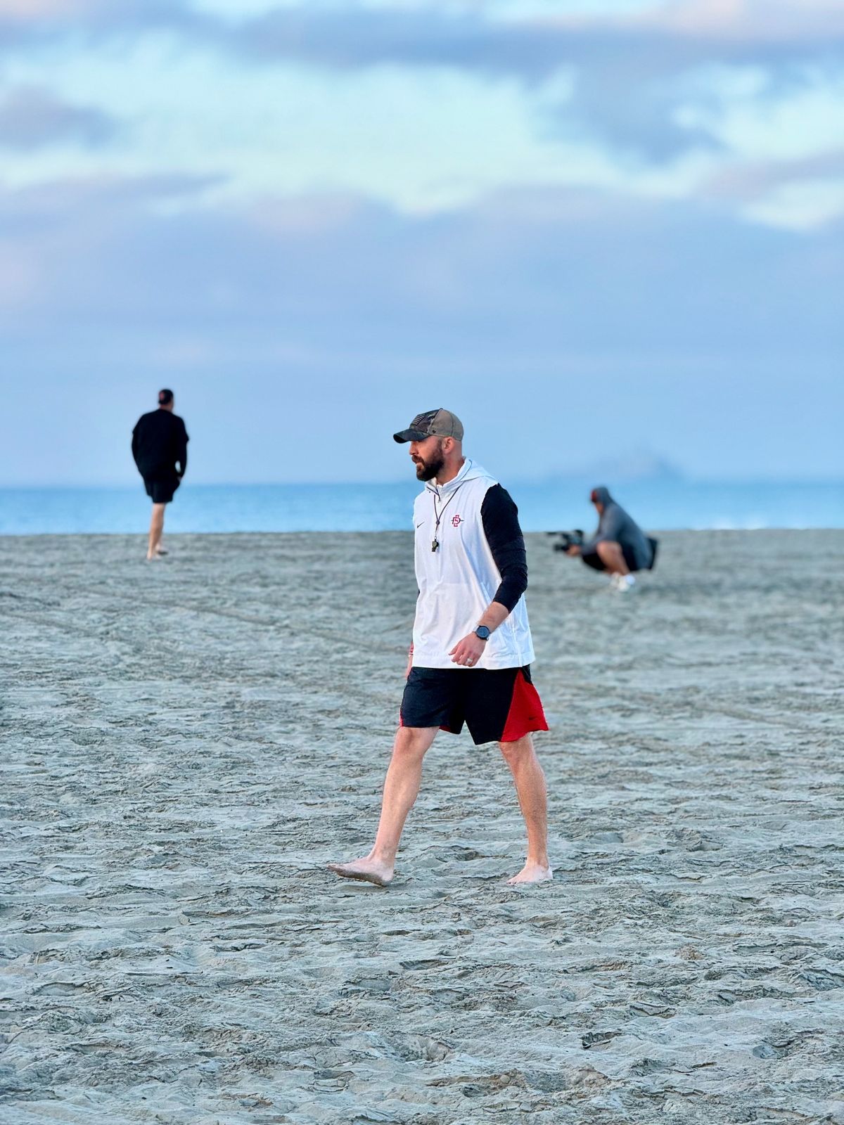 Sean Lewis stalks across the beach at Coronado Bay as his third Aztecs squad readies for a grueling workout. Sean Lewis stalks across the beach at Coronado Bay as his third Aztecs squad readies for a grueling workout.